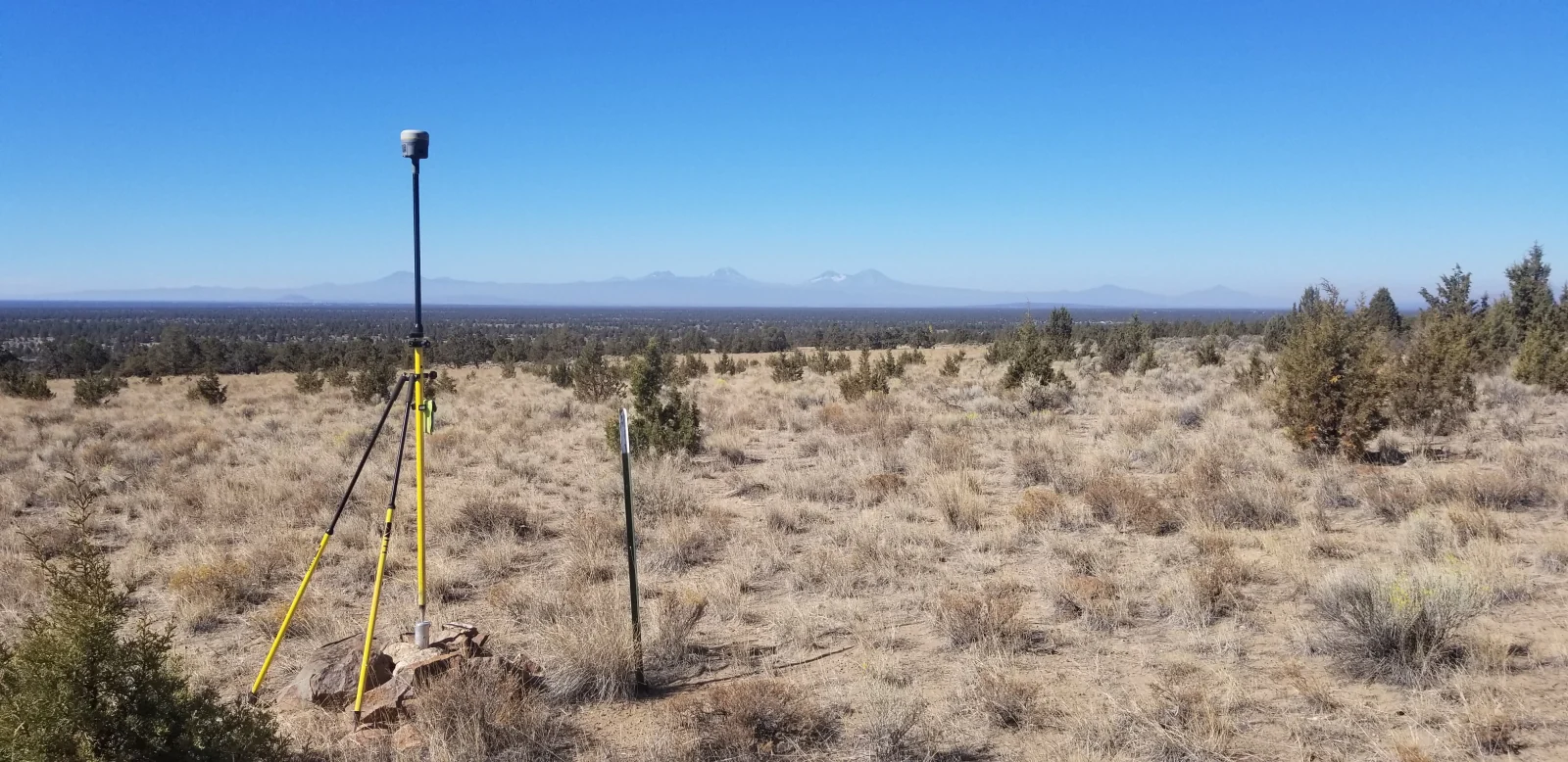 GPS survey receiver and tripod set up across open Central Oregon terrain